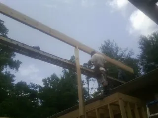 Carpenter setting a ridge beam over a new addition frame — Ice Dam Removal by Roofing Brothers in Port Trevorton