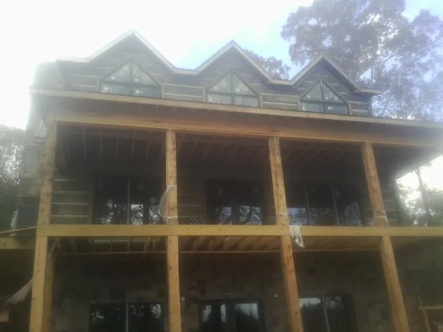 Dormers and porch framing on a large log home under construction — Roof Coating work by our crew in Port Trevorton
