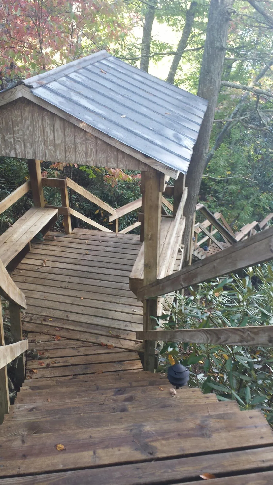 Metal roofed shelter over wooden steps on a wooded walkway — Skylight Repair & Installation work by our crew in Port Trevorton