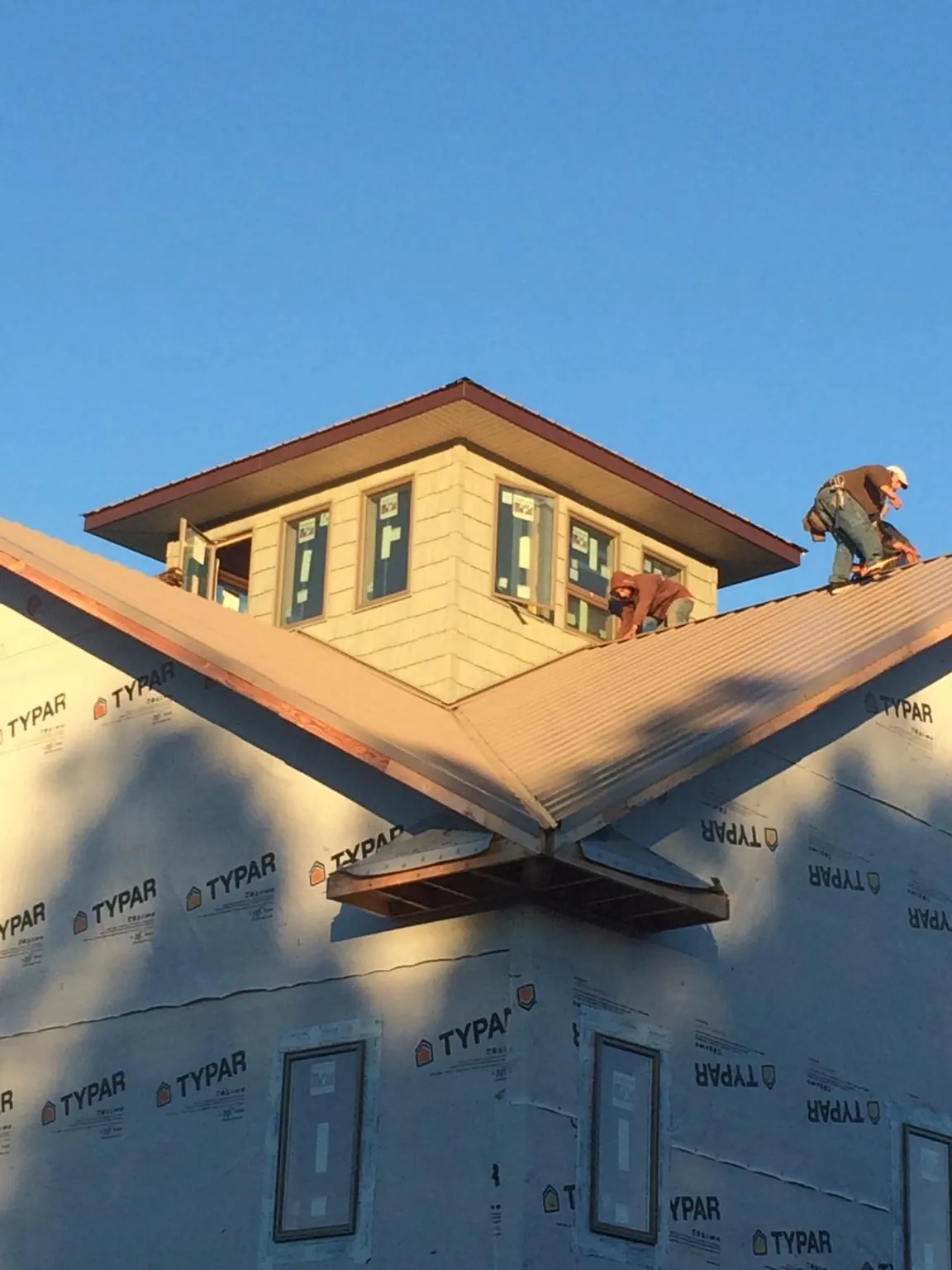 Roofers working around a rooftop cupola on a new metal roof at sunset — Roof Waterproofing in Port Trevorton by Roofing Brothers